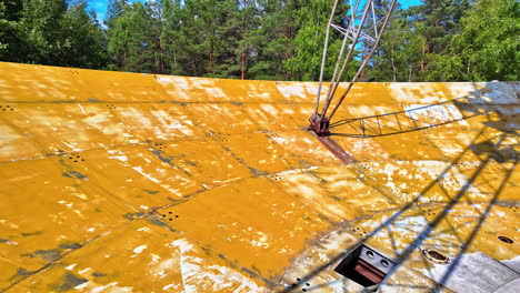 On-top-of-the-International-Radio-Astronomy-Center-on-a-beautiful-day,-walking-around-in-slow-motion,-green-trees-around