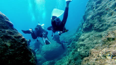 Group-of-divers-underwater-in-beautiful-sea-near-Greece,-POV-view