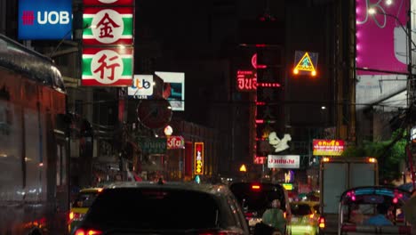 Bustling-city-streets-shimmer-with-neon-lights,-signage-and-vehicles