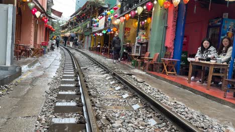 Hanoi-Bahnstraße,-Vietnam,-Statische-Aufnahme,-Leute-Sitzen-Am-Gleis---Top-10-Tourismusziele