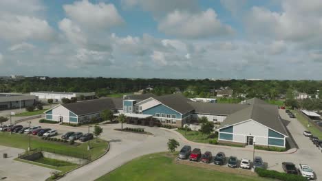 An-aerial,-establishing,-half-orbit-drone-view-of-the-Ignite-Medical-Resort-on-Highway-3-in-Webster,-Texas