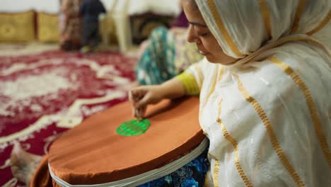 woman-handmade-needlework-handicraft-pattern-of-sea-turtle-hawksbill-aquatic-in-middle-east-persian-gulf-wooden-hoop-round-shape-in-sand-beach-at-night-summer-season-local-people-in-Iran-countryside