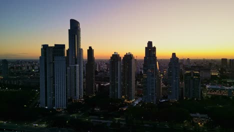 Aerial-drone-view-from-the-ecological-reserve-in-Puerto-Madero-with-a-view-of-the-buildings-and-sunset-colors-in-the-city-of-Buenos-Aires,-Argentina