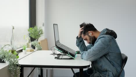 Joven-De-Oriente-Medio-Que-Trabaja-En-Un-Escritorio-Con-Una-Computadora-Portátil-Y-Parece-Estresado,-Frustrado-Y-Desesperado