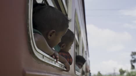 Niños-Asomándose-Desde-Un-Tren-En-Movimiento-En-Sri-Lanka-En-Un-Día-Soleado