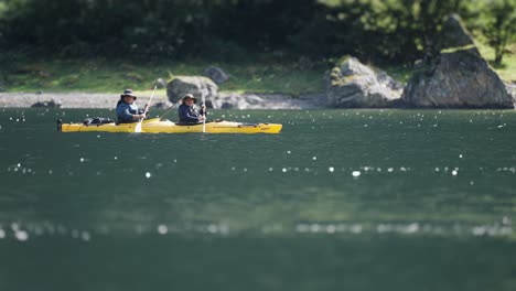 Una-Pareja-De-Kayakistas-Remando,-Balanceándose-Sobre-Las-Olas-A-Lo-Largo-De-Las-Orillas-Del-Fiordo-De-Naeroy.