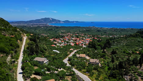 Aerial-shot-of-isolated-town-in-Greece-during-sunny-day-with-beautiful-landscape-of-mountains-at-background