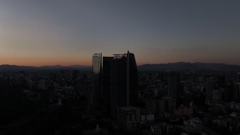 Paseo-de-la-Reforma-skyscrapers-at-dusk,-under-a-red-sunset