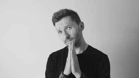 Footage-of-a-man-doing-a-praying-expression-while-putting-his-hands-together-in-a-prayer-motion-in-slow-motion-and-black-and-white-filmed-in-4K