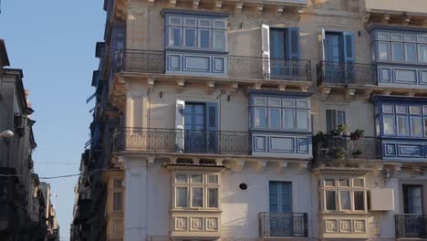 An-impressive-tilt-down-view-of-an-apartment-building-in-Valletta,-Malta,-highlighting-the-blend-of-modern-and-traditional-architectural-styles