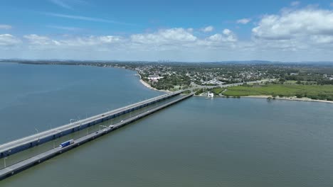 Drohnenaufnahme-Der-Ted-Smout-Memorial-Bridge,-Die-Kamera-Fliegt-Nach-Vorne-Mit-Der-Brücke,-Der-Moreton-Bay,-Dem-Meer-Und-Der-Stadt-Brisbane-Im-Hintergrund