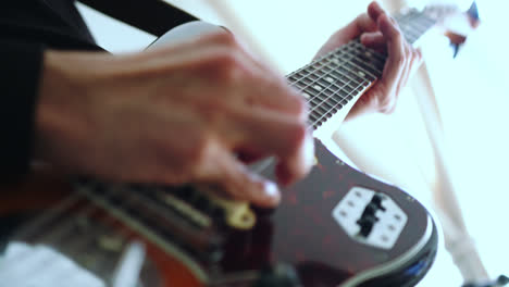 Wunderschöne-Zeitlupen-Detailaufnahme-Von-Händen,-Die-Ein-Instrumentalsolo-Auf-Der-E-Gitarre-In-Einem-Aufnahmestudio-Spielen,-Mit-Natürlichem-Licht,-Das-Vom-Balkon-Hereinfällt