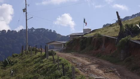 Mexico-flag-waving-on-hill-countryside-nature-landmark-in-Latin-America