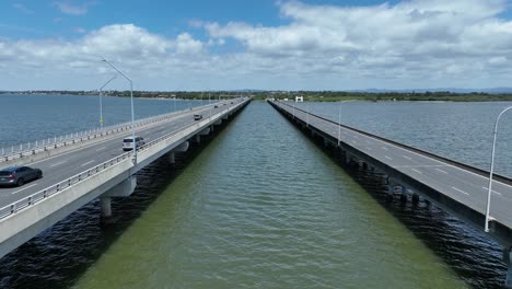 Toma-De-Aproximación-Desde-Un-Dron-Al-Puente-Conmemorativo-Ted-Smout,-Cámara-Volando-Entre-Los-Dos-Carriles-Del-Puente,-Siguiendo-A-Los-Autos-Mientras-Cruzan-El-Puente