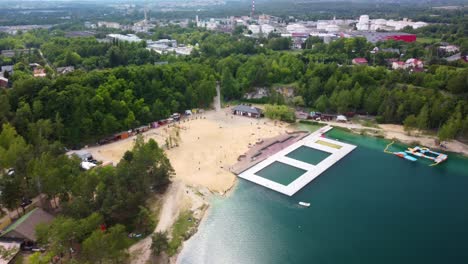 Aerial-view-of-the-natural-swimming-pool-Balaton-and-its-surroundings-with-lush-green-trees-in-Poland