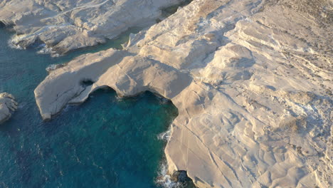 Aerial:-Slow-panning-drone-shot-of-Sarakiniko-beach-in-Milos-island,-Cyclades,-Greece-during-sunrise