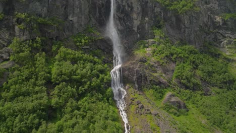 Majestic-Volefossen-waterfall-cascades-down-lush-green-cliffs-in-Norway