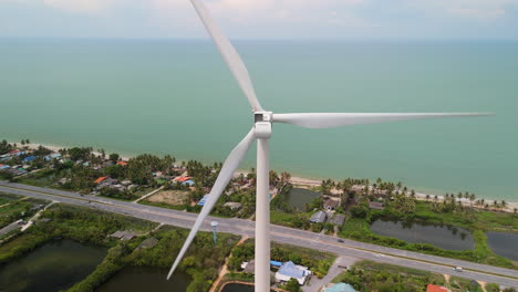 Wind-Turbine-on-the-Coast-Populated-Area-Windy-Area,-Greenhouse-Gas-Emissions-Renewable-Energy-Transition-Kilowatt-Generator