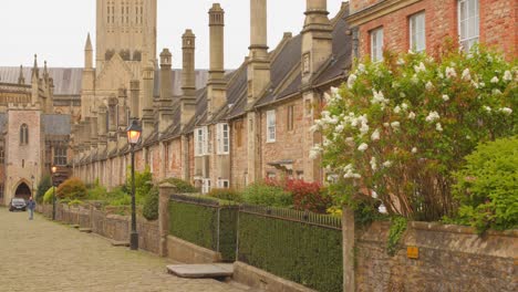 A-quiet-English-street-lined-with-charming,-historic-homes,-with-a-towering-church-in-the-background