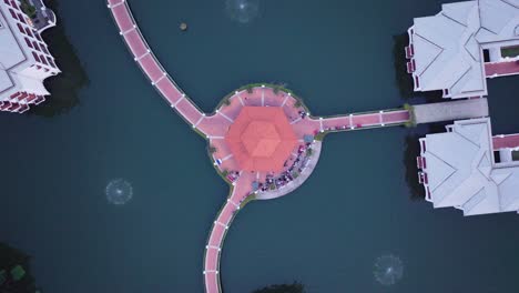 This-drone-footage-captures-a-stunning-aerial-view-of-Hanoi,-Vietnam,-focusing-on-a-beautifully-symmetrical-pavilion-surrounded-by-water