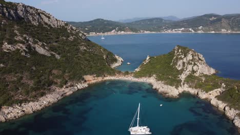 Porto-Timoni-Beach-near-Afionas-Village-with-an-anchored-Catamaran,-Corfu-Island,-Greece