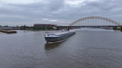 PRIMAIR-Cargo-Ship-Sailing-On-River-In-Alblasserdam,-Netherlands---Aerial-Drone-Shot