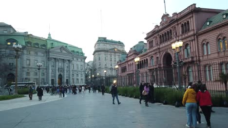 La-Gente-Camina-En-El-Lugar-Turístico-Argentino-En-La-Plaza-De-Mayo-Y-La-Casa-Rosada,-Toma-Panorámica-Del-Horizonte-Del-Atardecer