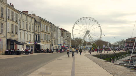 People-riding-bikes-in-La-Rochelle-old-port,-France