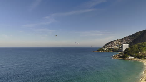 AERIAL:-Airplane-advertisement-on-the-coastline-of-Rio-de-Janeiro,-golden-hour