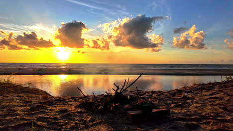 Serene-sunrise-over-the-ocean-with-glowing-fire-embers-in-the-foreground,-creating-a-peaceful-and-warm-morning-atmosphere