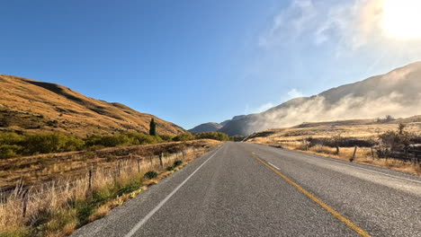 Driving-along-a-high-altitude-road-through-clouds-near-Aoraki,-Mount-Cook-National-Park