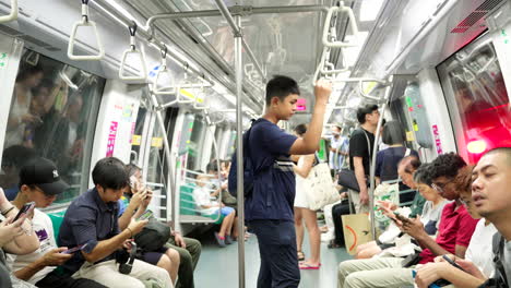 Rhythmic-thrum-of-underground-train,-residents-concentrate-smartphone-screens