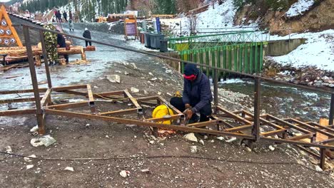 A-worker-does-the-welding-of-reinforcement-of-concrete-structures-during-the-frame-construction-of-a-residential-apartment-building