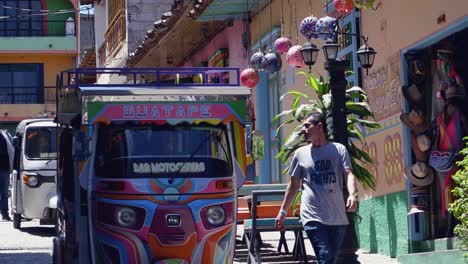 3-wheel-Tuk-Tuk-taxi-drives-on-cobble-stone-street-in-Guatape-Colombia