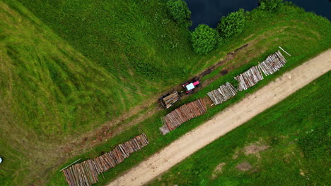 Wooden-cut-logs-getting-stacked-up-by-a-log-grapple