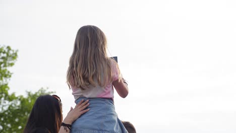 slow-motion-shot-of-a-child-on-shoulders-watching-the-Olympic-torch-relay