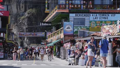 Una-Multitud-De-Turistas-Pasea-Por-Las-Coloridas-Tiendas-De-La-Calle-En-Guatapé,-Colombia.