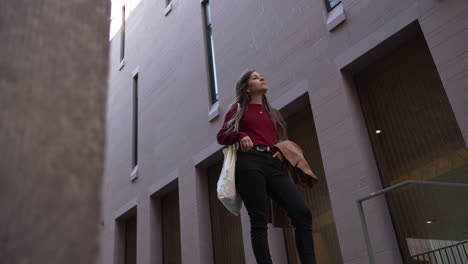 Mujer-Modelo-Morena-Vestida-De-Manera-Elegante-Y-Casual-En-La-Ciudad,-Toma-A-Baja-Altura