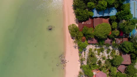 Drohnenaufnahmen-über-Einem-Strand-Auf-Der-Thailändischen-Insel-Koh-Tao,-Die-Klares-Wasser-Und-Unterkünfte-Am-Strand-Zeigen