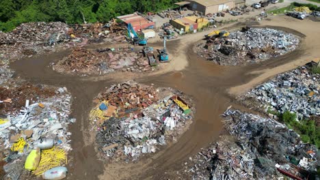 high-drone-eye-view-clockwise-orbiting-scrapyard-on-a-bright-sunny-day