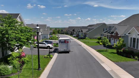 Fed-ex-Truck-at-work-on-street-in-upper-class-neighborhood-during-sunny-day