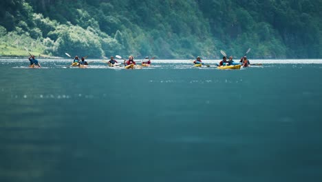 Un-Grupo-De-Kayakistas-Disfruta-De-Las-Tranquilas-Aguas-Del-Fiordo-De-Naeroy,-Mientras-Sus-Embarcaciones-Se-Balancean-Con-Las-Olas.