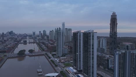 Aerial-drone-view-from-Puerto-Madero-with-a-view-of-the-buildings-and-docks-at-sunset-in-the-city-of-Buenos-Aires,-Argentina