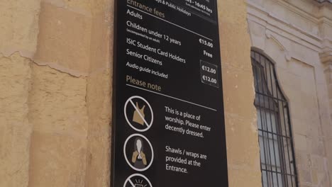 A-tilt-down-shot-of-the-pricing-list-of-a-museum-in-Valletta,-Malta