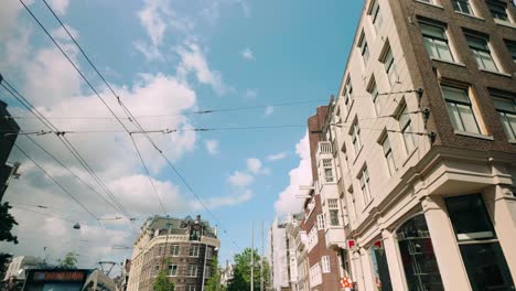 Low-angle-pov-to-Amsterdam-city-architecture-with-apartments,-houses,-and-tramline