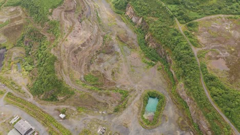 Vista-Aérea-De-Una-Cantera-Abandonada-Que-Vuelve-Lentamente-A-La-Naturaleza-Con-Vegetación-Que-Vuelve-A-Crecer.