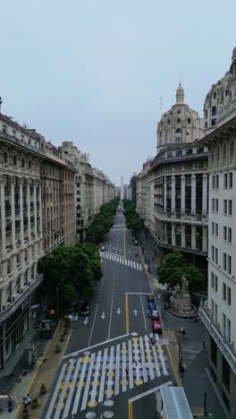 Aerial-zoom-in-descent-view-of-Diagonal-Norte-Street,in-Buenos-Aires,-Argentina-on-a-cloudy-sky