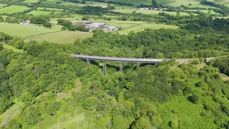 Aerial-view-of-Meldon-Viaduct,-a-disused-railway-bridge-crossing-West-Okement-River,-now-a-pedestrian-pathway