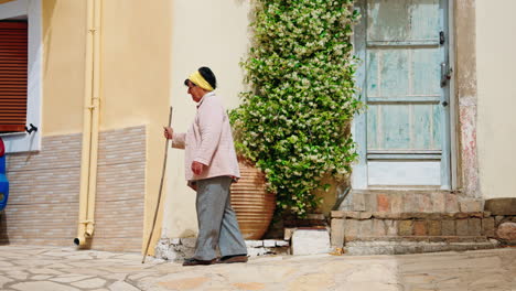 Una-Anciana-Griega-Caminando-Por-La-Calle-Con-Un-Bastón-En-El-Pueblo-De-Lakones-En-Corfú