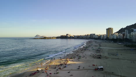 Aerial-view-rotating-over-people-on-the-Copacabana-Beach,-sunset-in-Rio,-Brazil